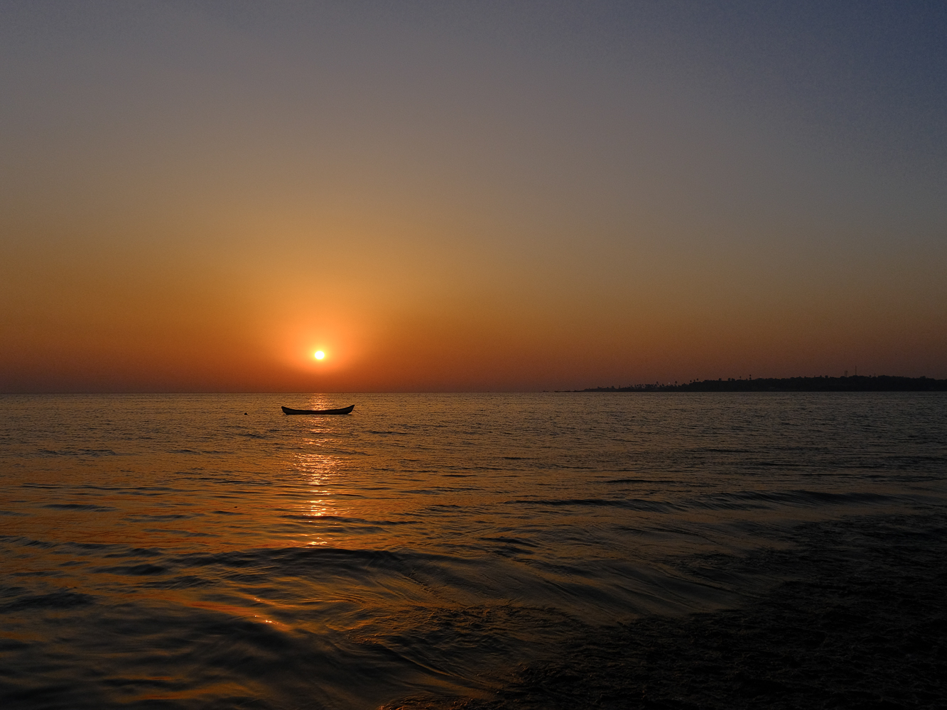 A boat against the setting sun